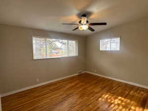 Unfurnished room featuring ceiling fan, hardwood / wood-style floors, and vaulted ceiling