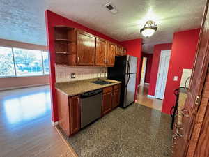 Kitchen featuring sink, a textured ceiling, and appliances with stainless steel finishes