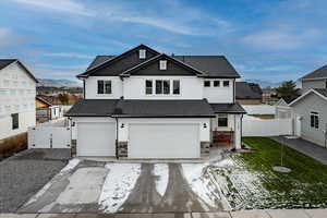 View of front of home featuring a mountain view, a front lawn, and a garage