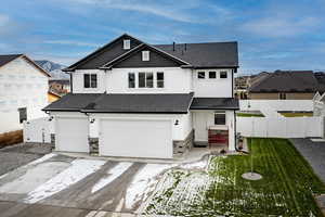 View of front of property featuring a garage and a front yard