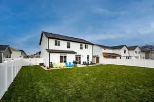 Rear view of house with a patio area, cooling unit, a storage shed, and a lawn