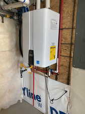 Utility room featuring electric panel and water heater