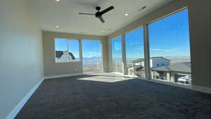 Interior space with carpet, a mountain view, and ceiling fan