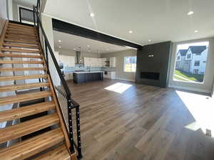 Unfurnished living room featuring a fireplace, dark hardwood / wood-style flooring, and sink