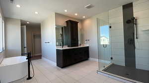 Bathroom featuring vanity, tile patterned flooring, and plus walk in shower