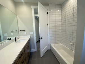 Bathroom with tile patterned floors, vanity, and tiled shower / bath combo