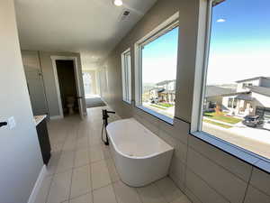 Bathroom featuring tile patterned floors and a tub to relax in