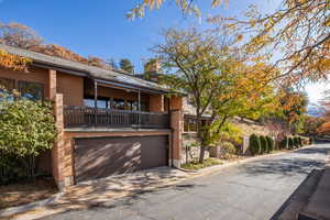 View of front of property featuring a garage and a balcony