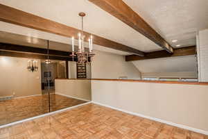 Dining area featuring parquet floors, beam ceiling.