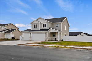 View of front facade featuring a front lawn and a garage