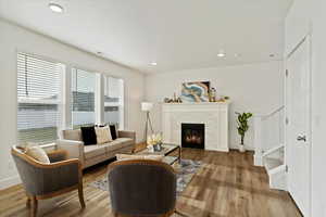 Living room featuring light wood-type flooring and a tiled fireplace