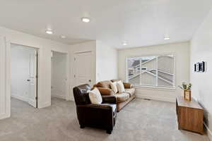 Sitting room featuring light carpet