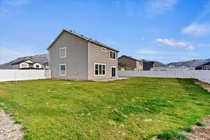 Rear view of house featuring a lawn and a mountain view