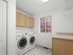 Laundry room featuring cabinets, countertop and included washer and dryer