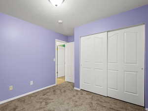 Bedroom #3 with light carpet, a textured ceiling, and a closet