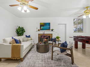 Family room featuring a tiled fireplace, ceiling fan, and light tile patterned floors