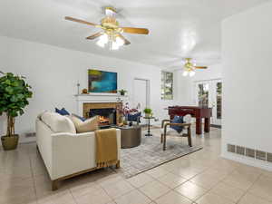 Tiled family room featuring ceiling fan, french doors, and a tiled fireplace