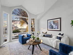 Living room featuring carpet and vaulted ceiling