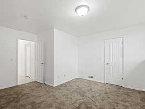 Bedroom #7  room featuring light carpet and a textured ceiling, walk in closet.