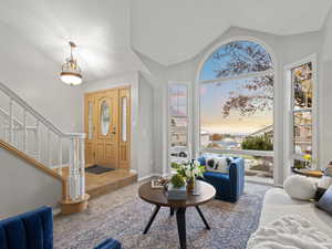 Entrance foyer featuring carpet floors, vaulted ceiling, and a healthy amount of sunlight