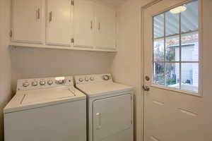 Laundry room with washing machine and dryer and cabinets