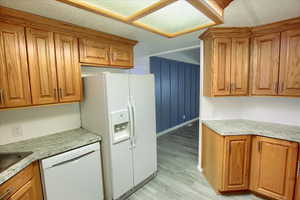 Kitchen with white appliances and light hardwood / wood-style floors