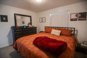 Carpeted bedroom featuring a textured ceiling