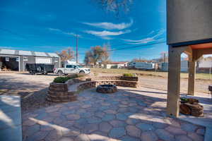 View of patio / terrace with a fire pit and an outdoor structure