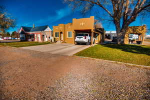 View of front of property with a front yard and a carport