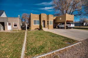 View of front of home featuring a front yard and a carport