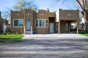 Pueblo revival-style home featuring a carport