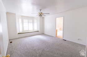 Empty room featuring light carpet, ceiling fan, and crown molding