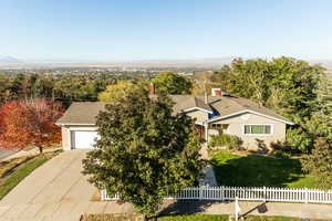 View of front of home with a mountain view, a front lawn, and a garage