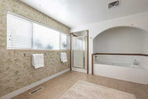 Bathroom with separate shower and tub and tile patterned floors