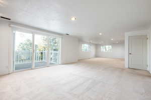 Unfurnished room with light colored carpet and a textured ceiling