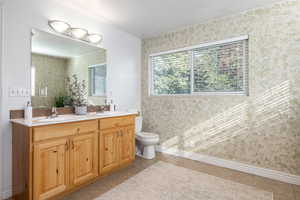 Bathroom with tile patterned flooring, vanity, and toilet