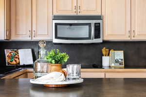 Kitchen featuring backsplash and light brown cabinetry