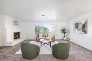 Living room with carpet flooring and a fireplace