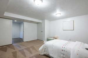 Bedroom with light carpet and a textured ceiling