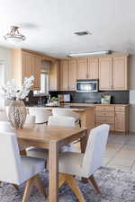 Kitchen with light brown cabinets, light tile patterned flooring, and a textured ceiling