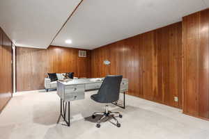 Carpeted office space with wood walls