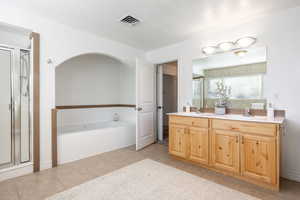 Bathroom with vanity, tile patterned floors, and independent shower and bath