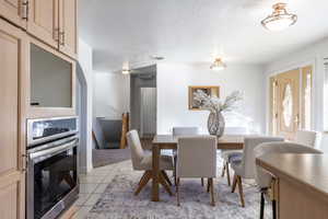 Tiled dining space featuring a textured ceiling