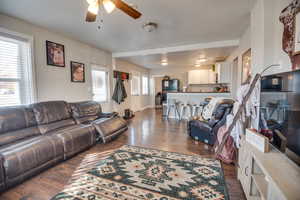 Living room with ceiling fan, a healthy amount of sunlight, and dark hardwood / wood-style floors