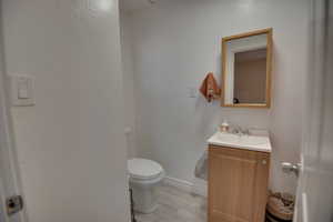 Bathroom featuring hardwood / wood-style flooring, vanity, and toilet