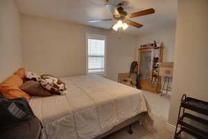 Carpeted bedroom with ceiling fan