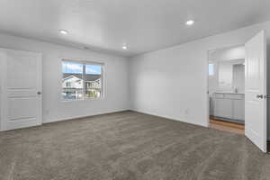 Carpeted empty room with a textured ceiling