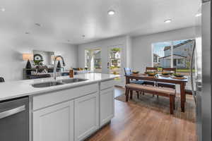 Kitchen with dark hardwood / wood-style flooring, stainless steel dishwasher, a textured ceiling, sink, and white cabinets