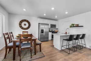 Kitchen featuring white cabinets, sink, stainless steel appliances, and light hardwood / wood-style flooring