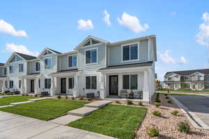 View of front of home with central AC unit and a front yard